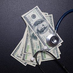 Moody Alabama one hundred dollar bills under stethoscope