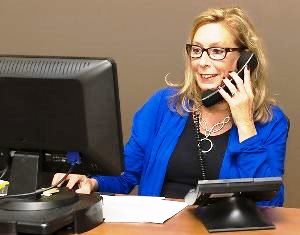 New Kingman Butler Arizona medical coding specialist at desk on phone